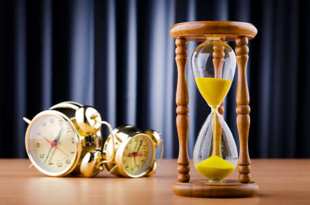 Time concept with alarm clock and hourglass