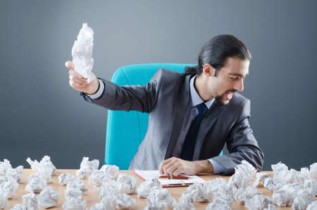 Businessman with lot of discarded paperの写真素材