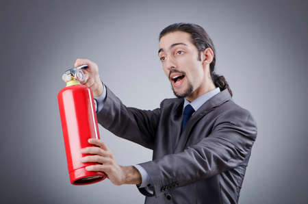 Man with fire extinguisher in firefighting conceptの写真素材