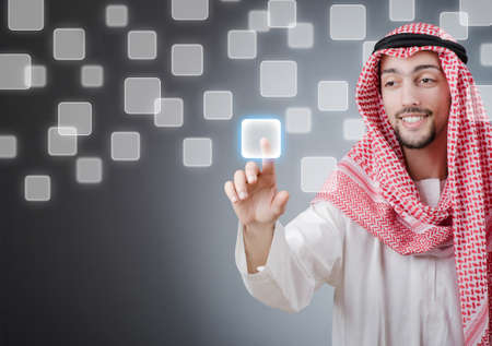 Young arab pressing virtual buttonsの写真素材