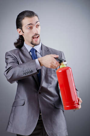 Man with fire extinguisher in firefighting conceptの写真素材