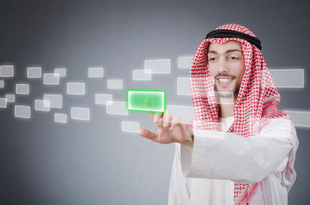 Young arab pressing virtual buttonsの写真素材