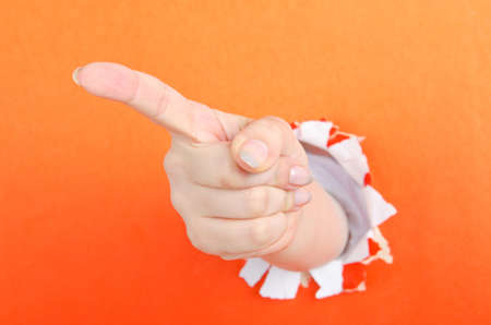 Hand out of paper hole