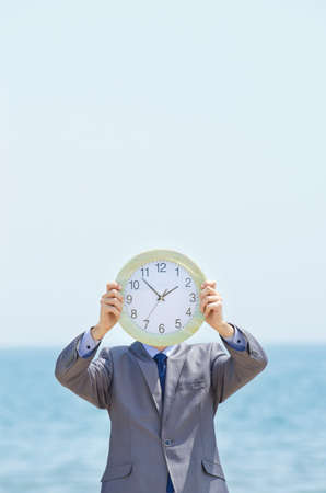 Man with clock on seasideの写真素材