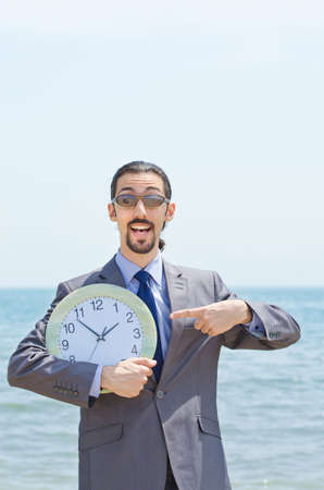 Man with clock on seasideの写真素材