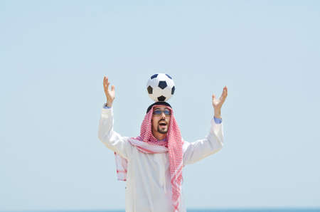 Arab with footbal at seasideの写真素材