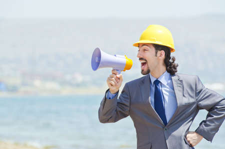 Man wearing helmet speaks with megaphone