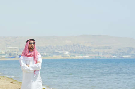 Arab on seaside in traditional clothingの写真素材