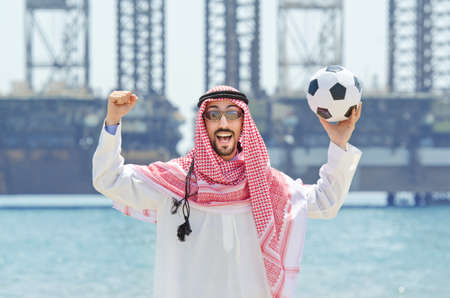 Arab with footbal at seasideの写真素材