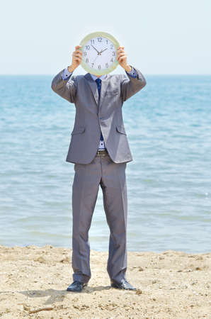 Man with clock on seasideの写真素材
