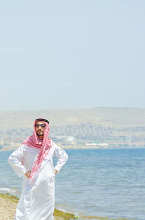Arab on seaside in traditional clothingの写真素材