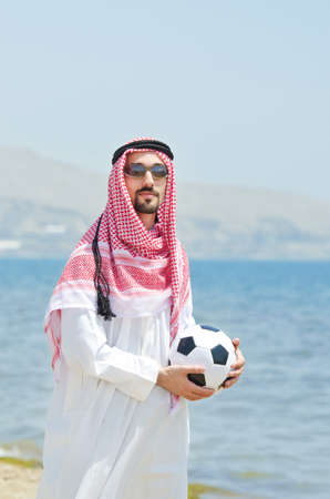 Arab with footbal at seasideの写真素材