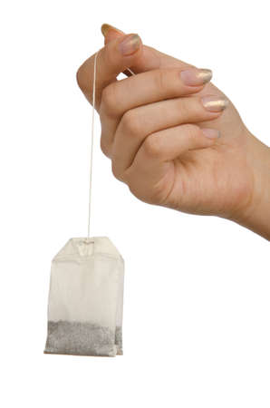 Hand holding teabag on whiteの写真素材