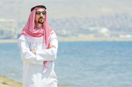Arab on seaside in traditional clothingの写真素材