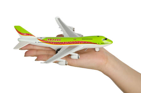 Hand holding toy airplane isolated on white
