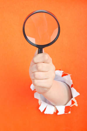 Hand holding magnifying glass の写真素材