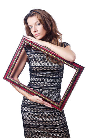 Young woman with picture frame on whiteの写真素材