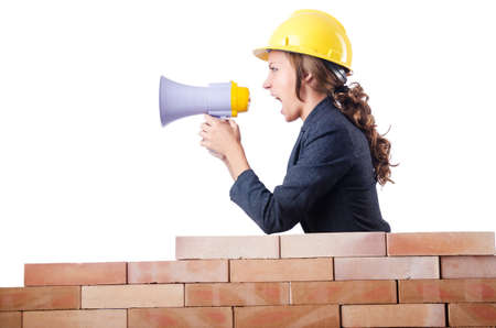 Woman builder with loudspeaker on whiteの写真素材