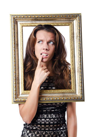 Young woman with picture frame on whiteの写真素材