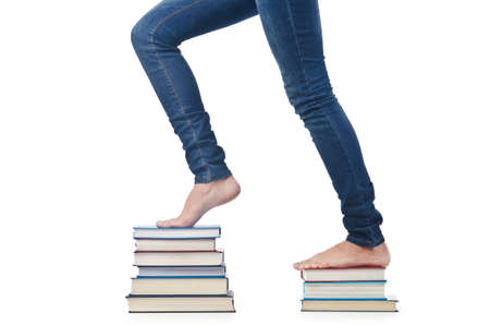 Student sitting on stack of booksの写真素材