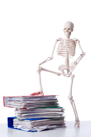 Skeleton with pile of files on whiteの写真素材