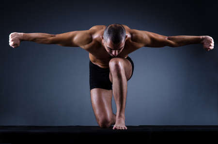 Muscular man in dark studioの写真素材