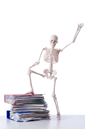 Skeleton with pile of files on whiteの写真素材