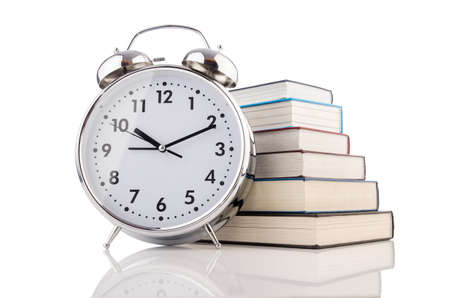 Alarm clock and books isolated on white