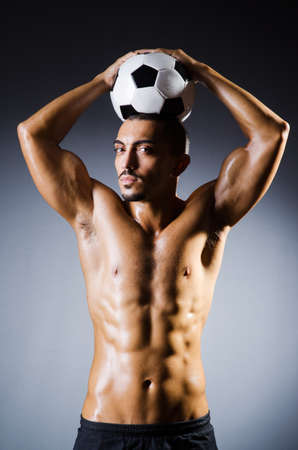 Muscular man with football ballの写真素材
