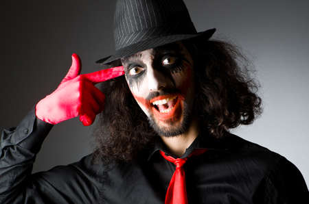 Joker personification with man in dark roomの写真素材