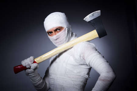Mummy with axe in halloween conceptの写真素材