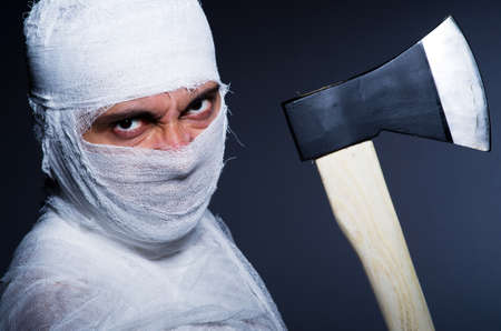 Mummy with axe in halloween conceptの写真素材