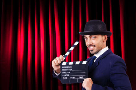 Man with movie clapper on curtain backgroundの写真素材