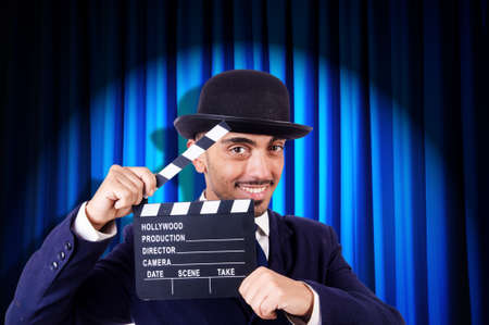 Man with movie clapper on curtain backgroundの写真素材