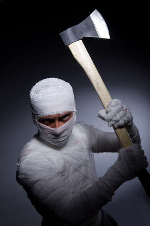 Mummy with axe in halloween conceptの写真素材