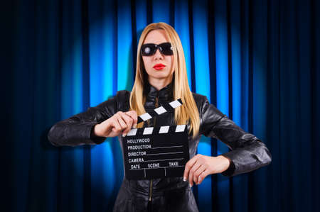 Girl with movie board against curtainsの写真素材