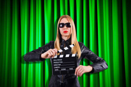 Girl with movie board against curtainsの写真素材
