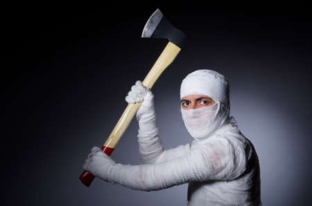 Mummy with axe in halloween conceptの写真素材