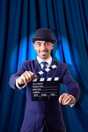 Man with movie clapper on curtain backgroundの写真素材