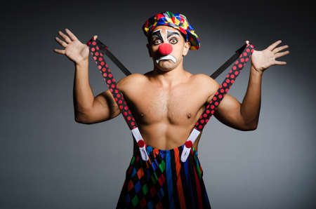Sad clown against dark background