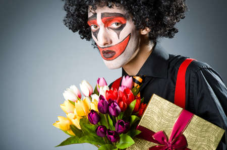Sad clown with the flowers