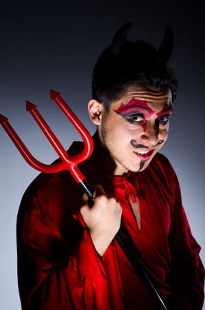 Man in devil costume in halloween conceptの写真素材