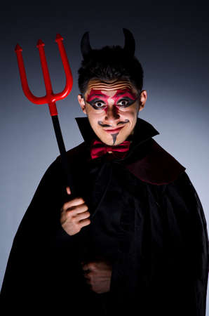 Man in devil costume in halloween conceptの写真素材