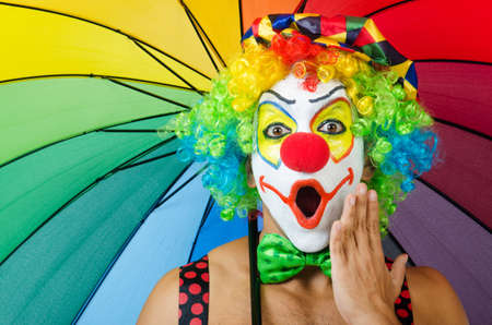Clown with umbrella isolated on whiteの写真素材