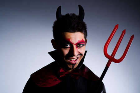 Man in devil costume in halloween concept
