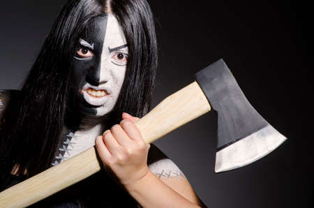 Woman monster with axe in dark roomの写真素材