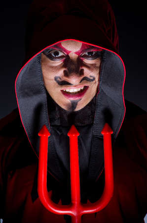 Man in devil costume in halloween concept