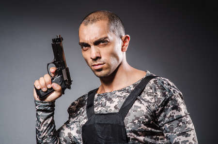 Soldier with guns against dark backgroundの写真素材