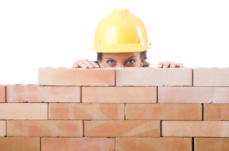 Young female builder near brick wallの写真素材