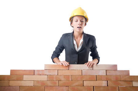 Young female builder near brick wallの写真素材